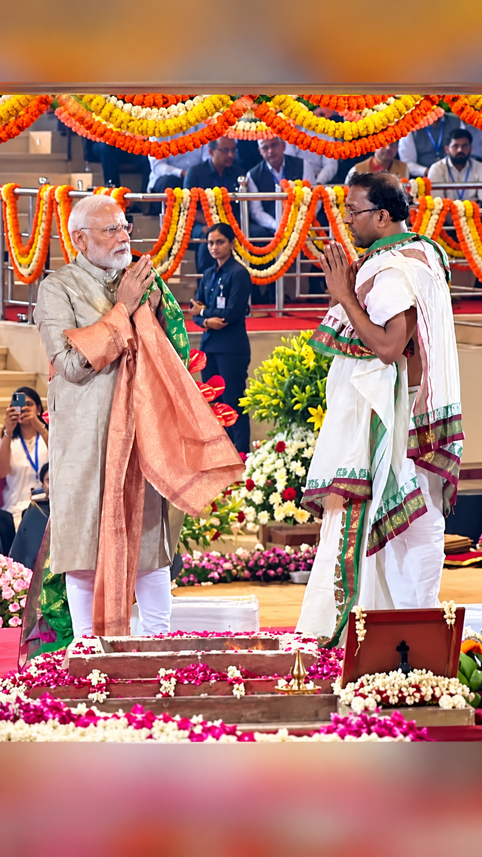 Shri Narendra Modi exchanging a namaste greeting with a priest during a religious ceremony